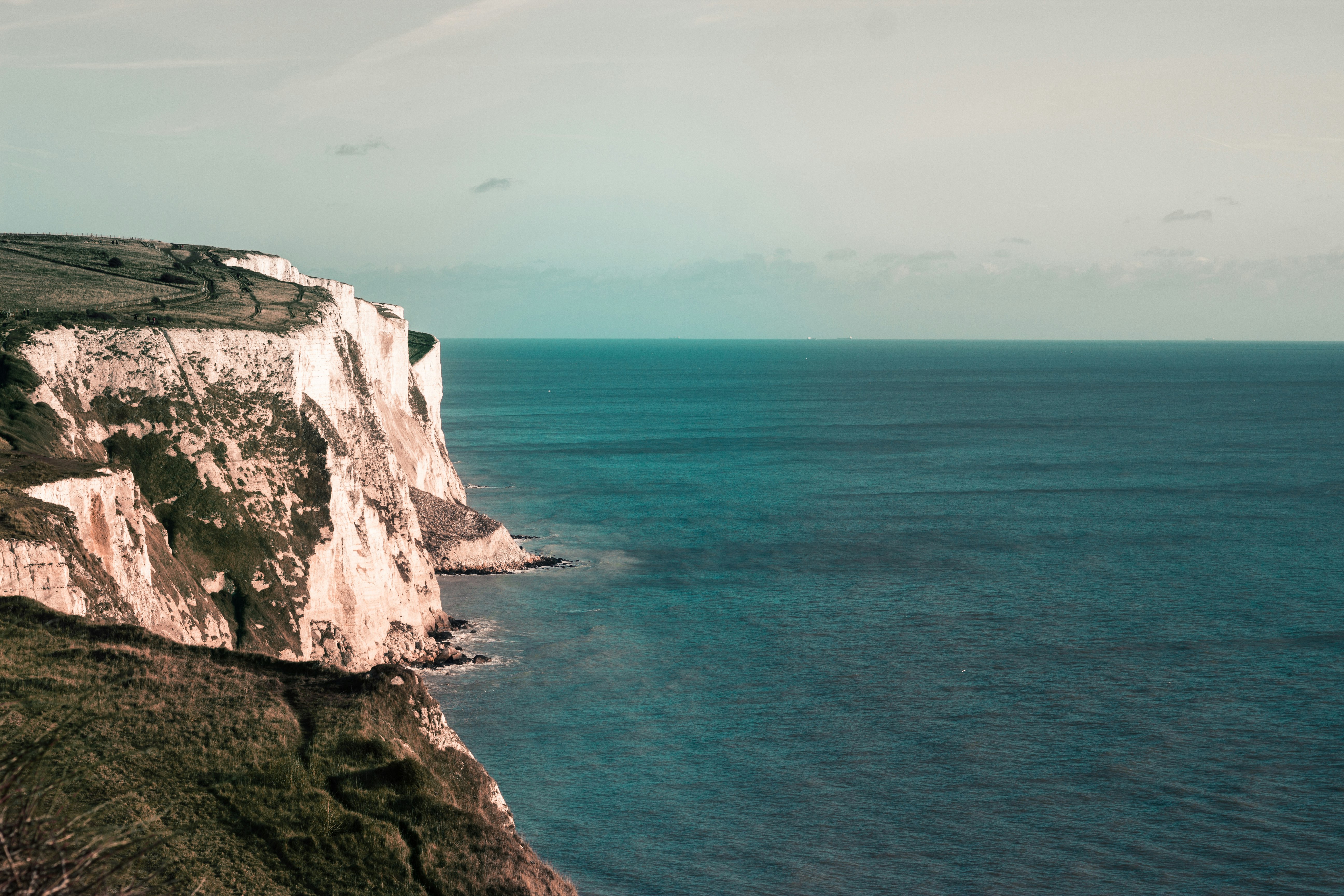 body of water beside cliff